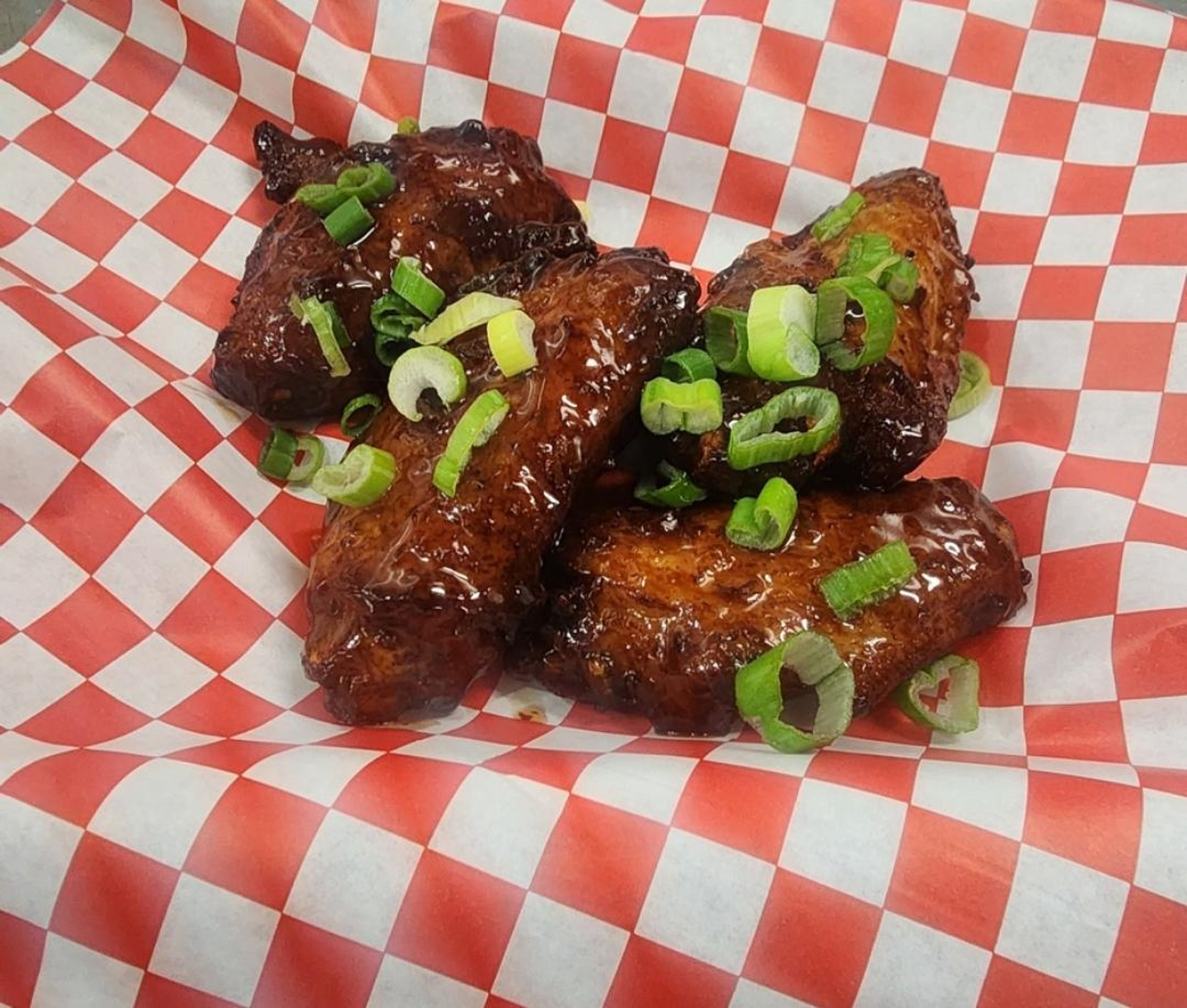 ORANGE CHICKEN SAUCE WINGS with green onions.