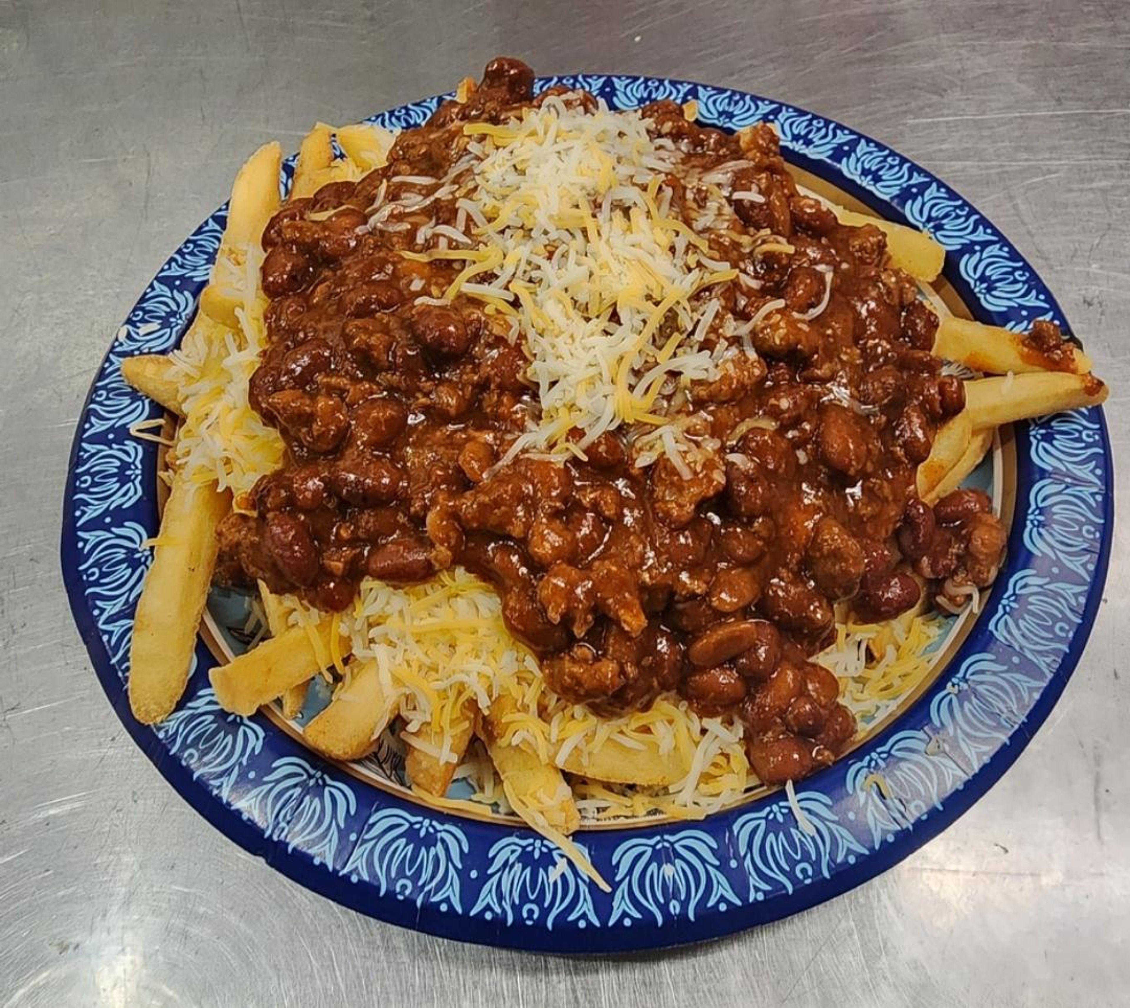 Chili cheese fries topped with cheese.