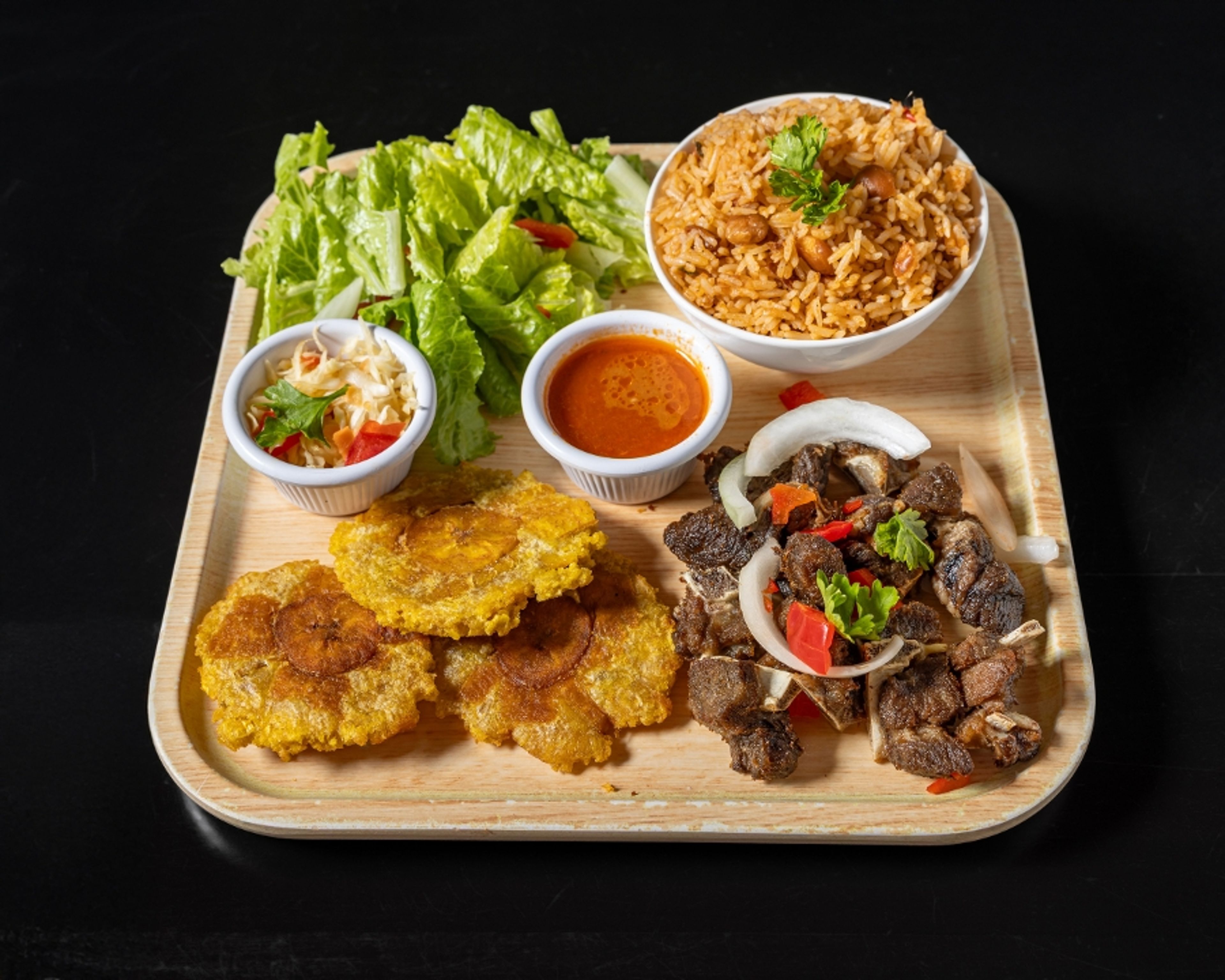 Fried Goat (served with plantain and 1 choice of white rice, rice and beans,  djondjon rice or  white rice and beans sauce).