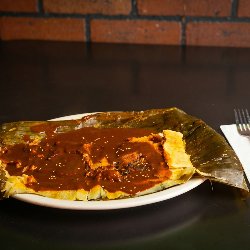Mole rojo tamale en hoja de platano.
