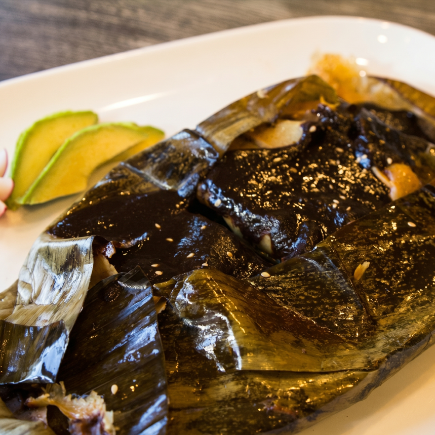 Mole negro tamale en hoja de platano.