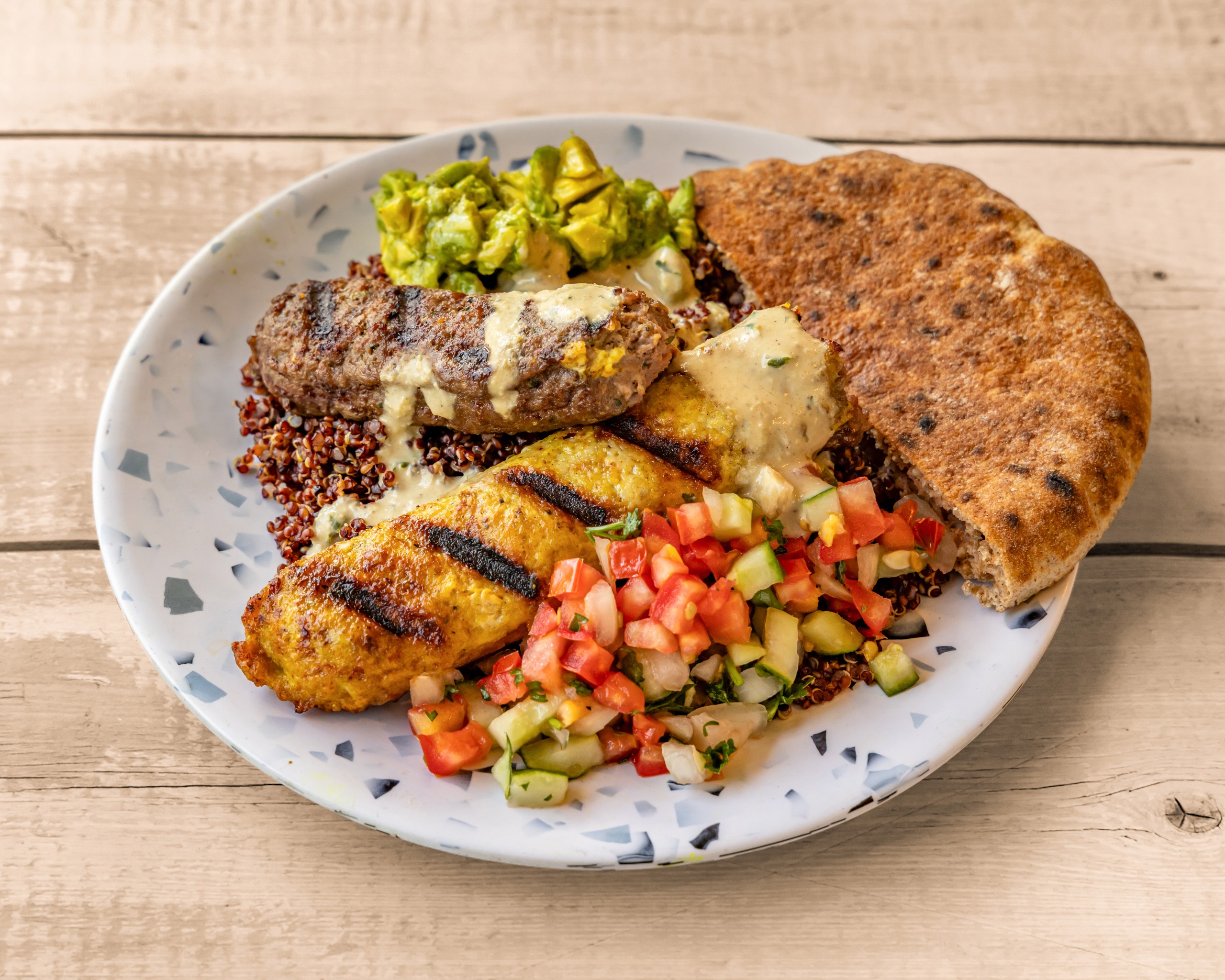 Mixed Grilled Kebab, Avocado Hummus, Israeli Salad, Tahini, 1/2 Pita.