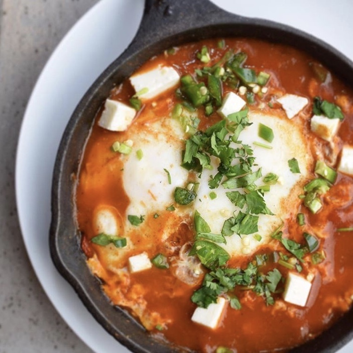 Shakshuka, 2 Eggs Poached in Tomato Sauce, Shredded PB cheese, Onions, Cilantro, Serrano Peppers (V)s 1/2 pita.
