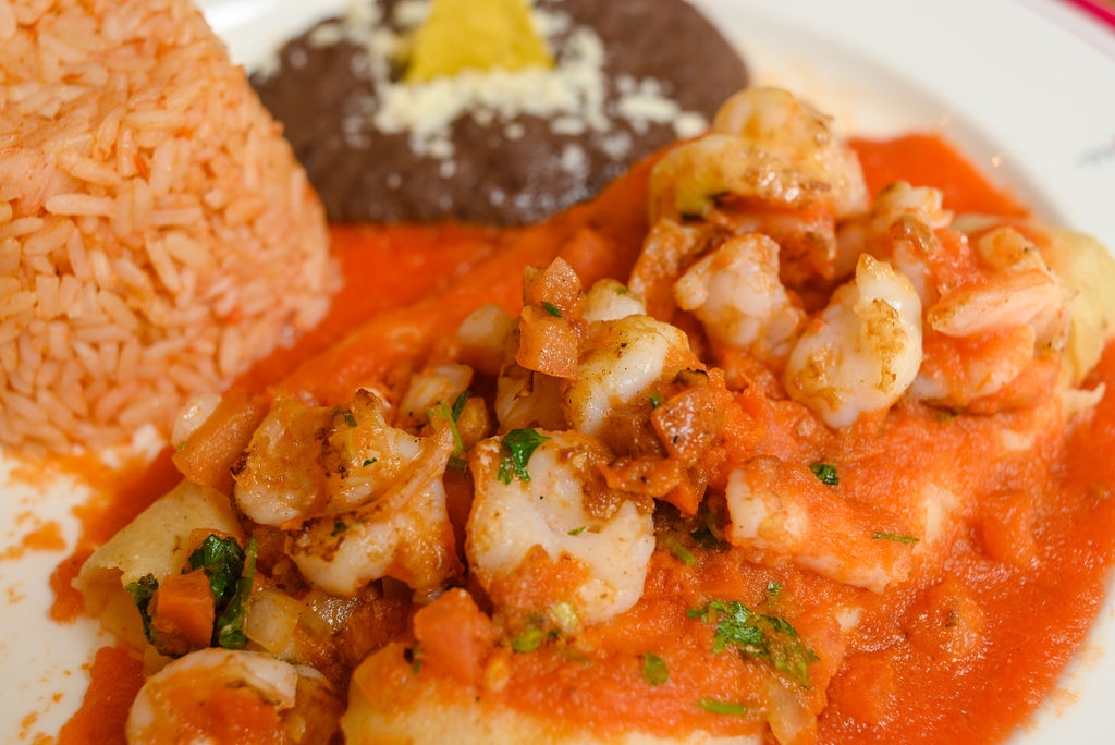 Red Shrimp Enchiladas / shrimps are on top and filled with cheese..