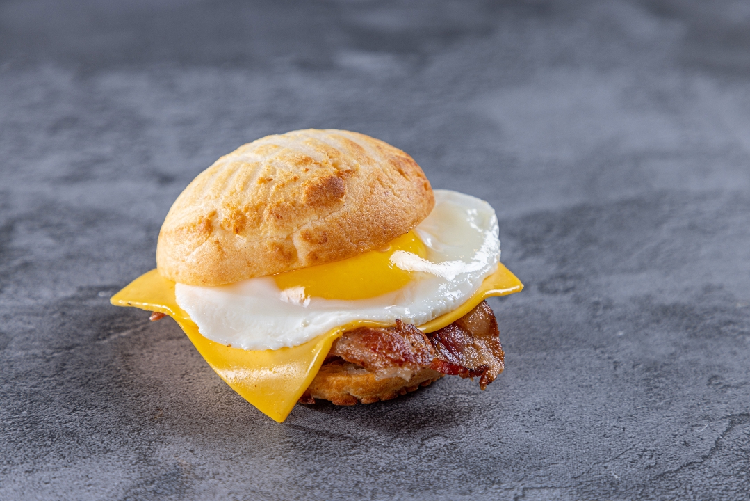 Huevos con tocineta, pandebono & queso Suizo.