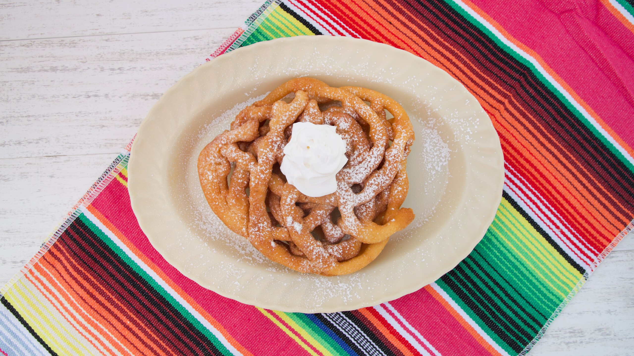 Funnel Cake with Powdered Sugar and Whipped Cream.